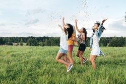 Group of women throwing confetti in a field