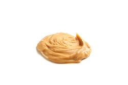 Creamy peanut butter isolated on light background. A traditional product of American cuisine