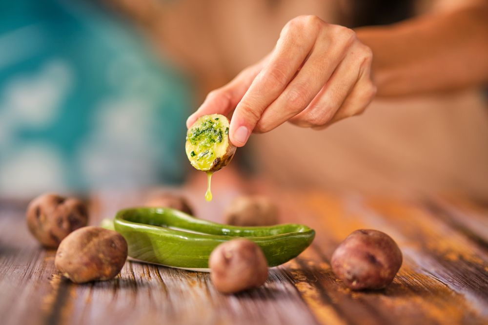 Crop woman dipping potato into sauce