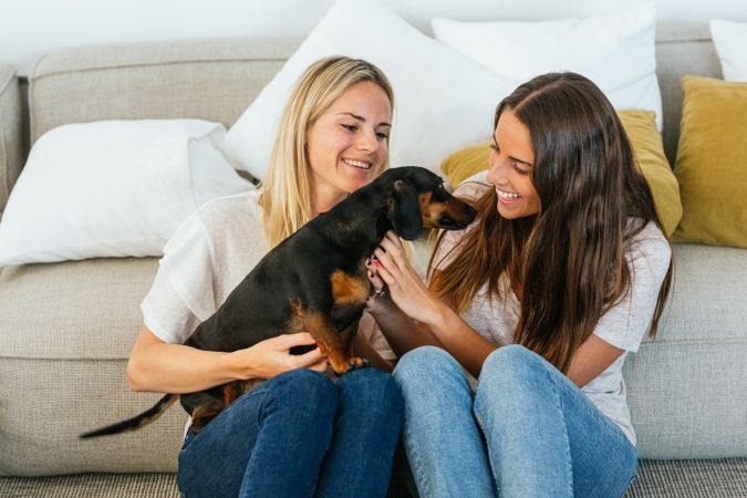 Smiling girlfriends with cute dog