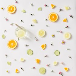 Colorful pattern made of orange, lemon, lime and flowers with lemonade