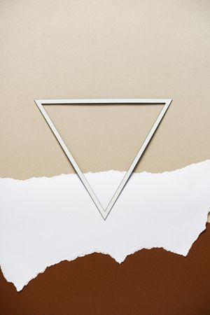 Earthy brown, beige and light torn paper background with triangle frame