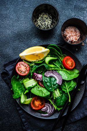 Top view of spinach salad with cherry tomatoes, served with sesame seeds