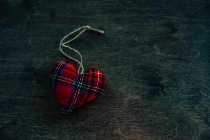 Valentine's day concept of tartan heart decorations on wooden table with space for text