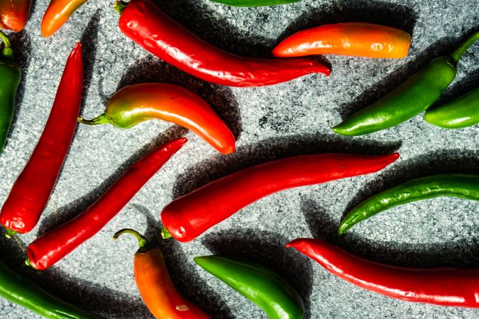 Spicy peppers scattered on grey kitchen counter