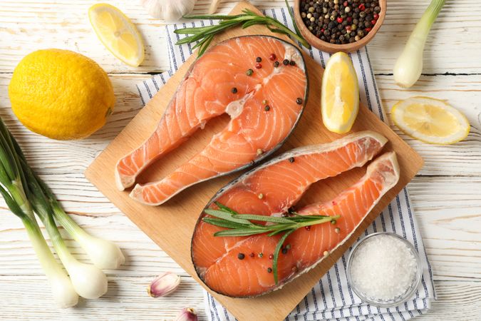 Composition with salmon meat and spices on wooden background, top view