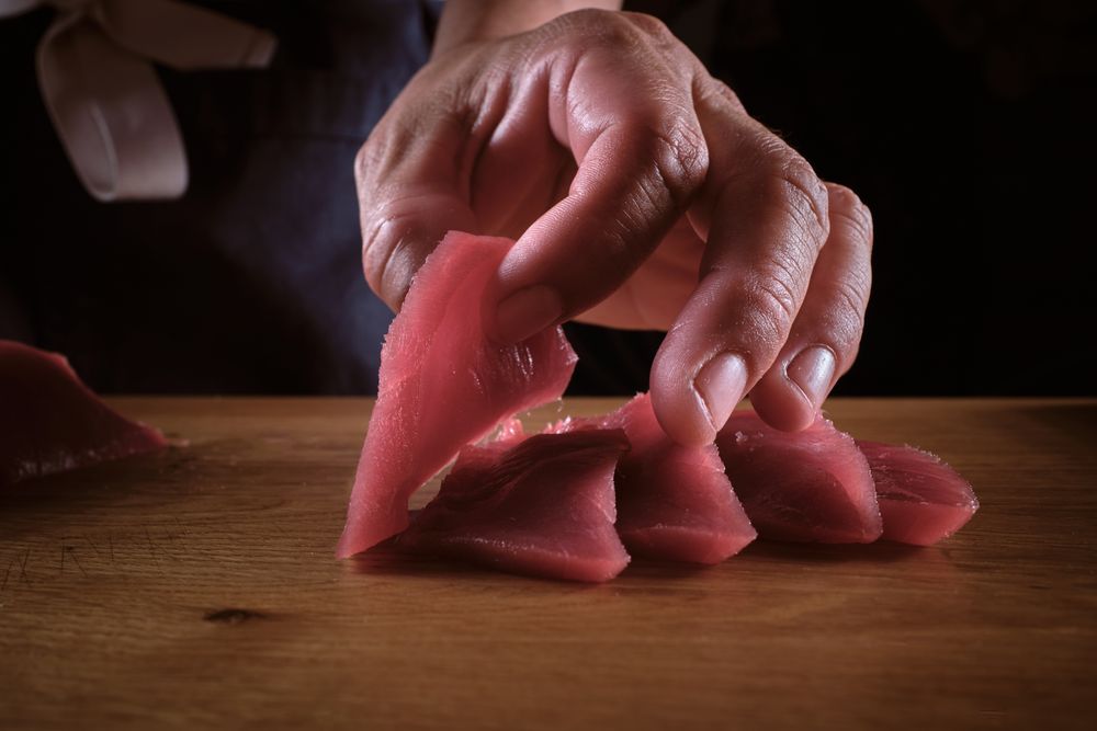 Male hands slicing fresh bluefin tuna loin