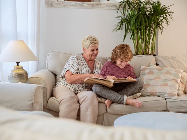 Mature woman with grandson exploring family photo album