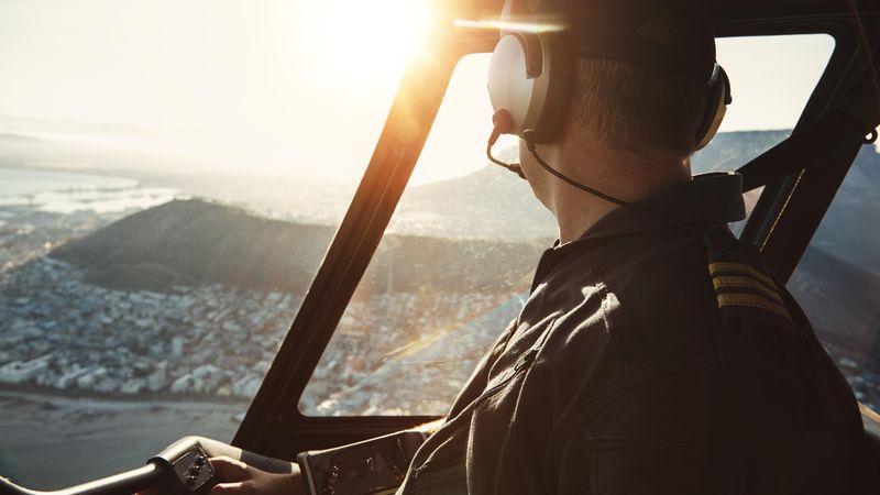 Man looking away while flying helicopter over Cape Town