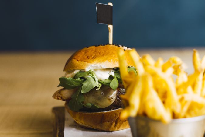 Juicy delicious burger and fried potato on table