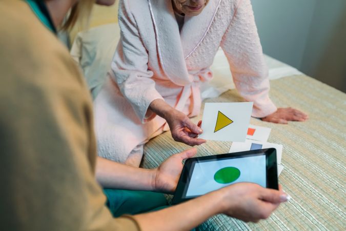 Female doctor showing geometric shapes to mature patient
