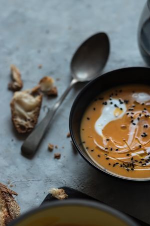 Bowls with pumpkin cream soup on table