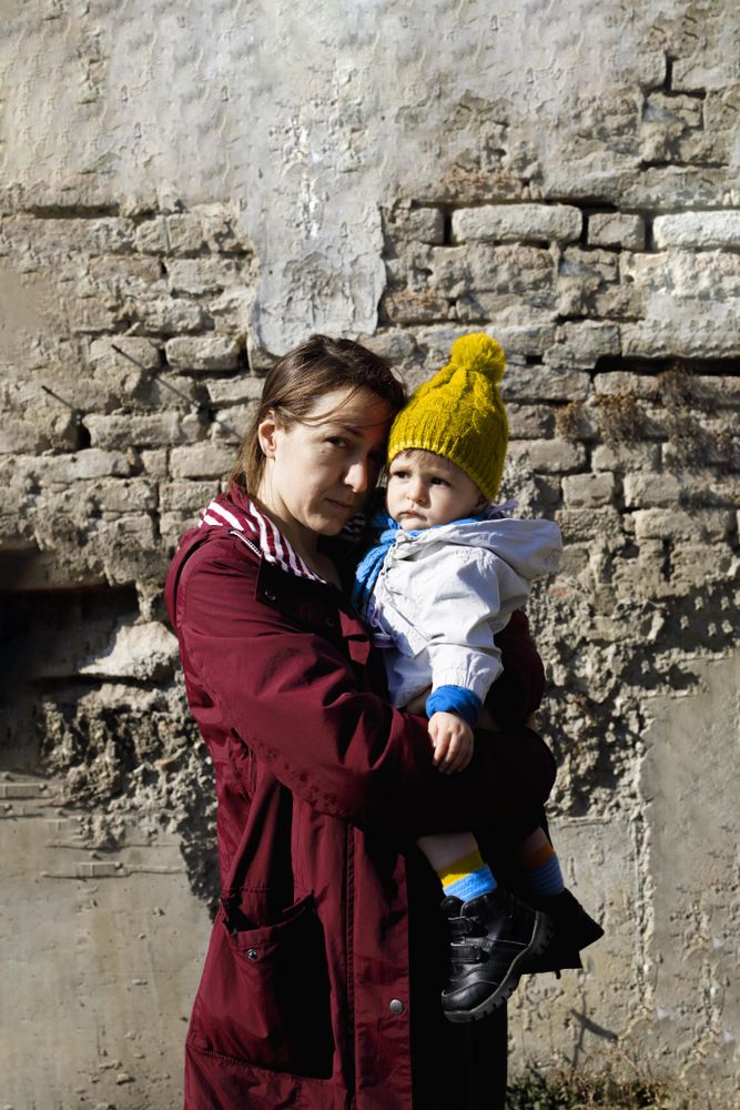 Mother holding baby in yellow hat