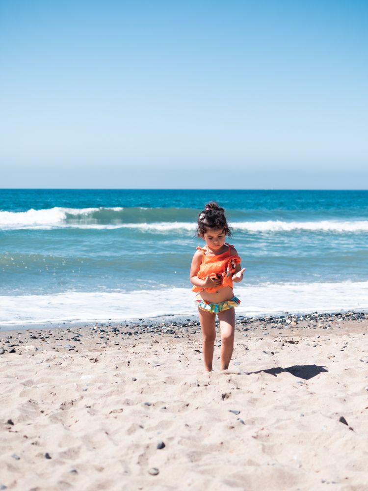 Cute twins girls playing on sandy beach