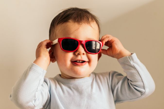 funny baby with sunglasses sitting at home