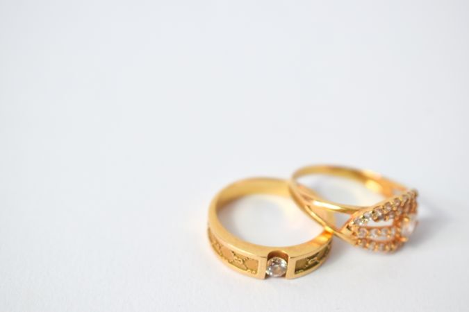 Two gold wedding rings together on plain table with copy space