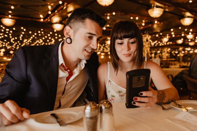 Couple using smartphone in luxury restaurant
