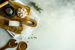 Top view of salt and pepper shakers, thyme and garlic on cutting board with copy space