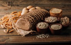 Wholegrain food pasta and freshly baked rye bread on table