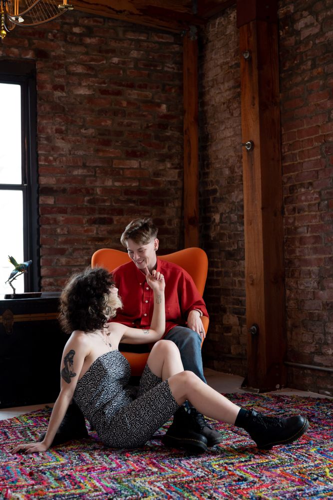 Woman sitting on floor touches her partner’s chin while smiling