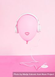 Pink balloon with lips wearing headphones plugged into pink desk bEAJ6b