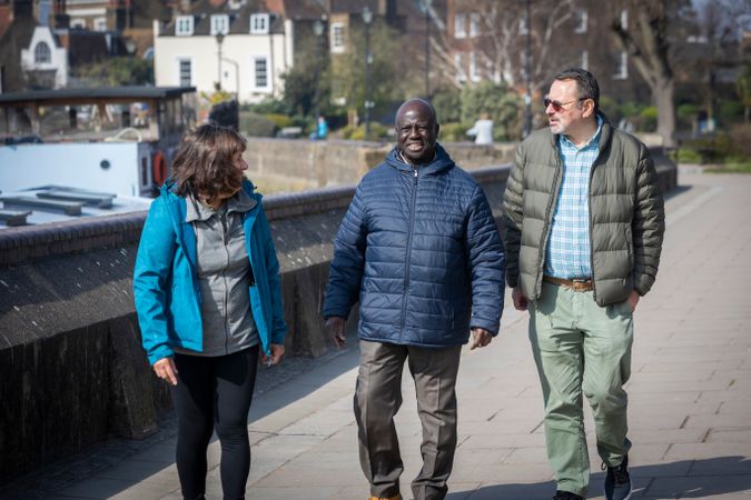 Multi-ethnic group of older adults walking and chatting outside