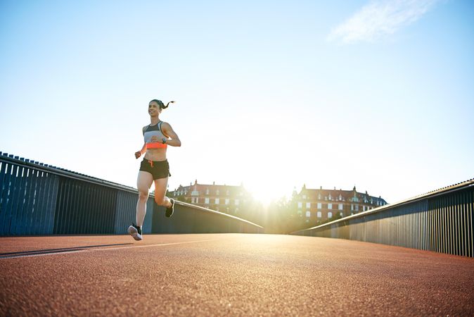 Bridge in the morning with smiling female jogger