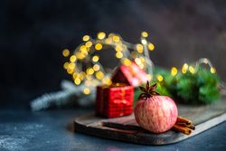 Apple on table with star anise and cinnamon stick on wooden board
