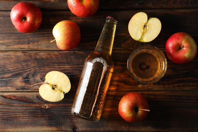 Composition with cider and apples on wooden background