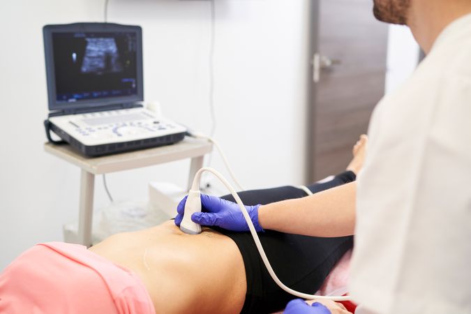 a physiotherapist performing an ultrasound scan for pelvic floor