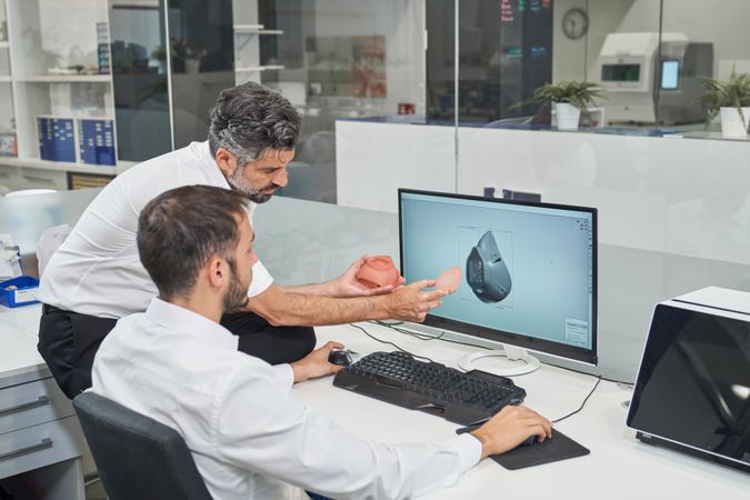 Engineers designing respirator on computer