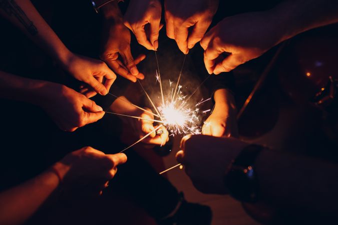 People holding lighted sparkler during nighttime