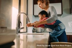 Cute son washing hands with mother in the sink after cooking 4Am884