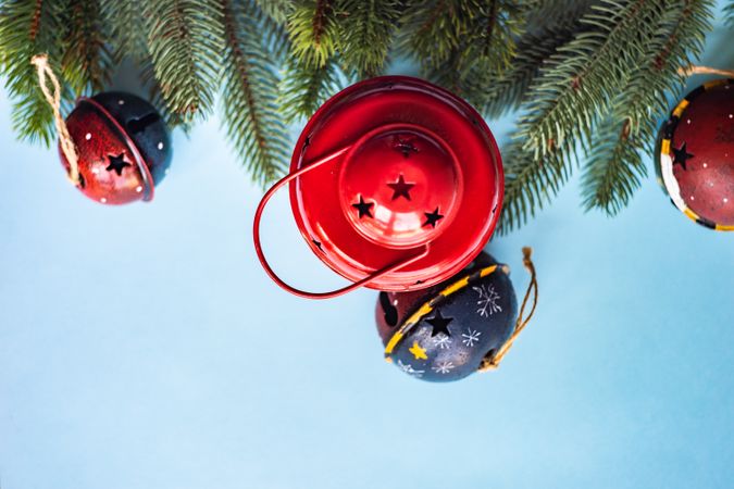 Top view of festive red lantern, bell and branch on blue background