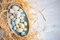 A bowl of Easter eggs surrounded with hay