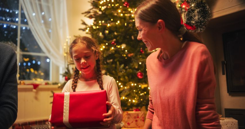 Happy Little Family Exchanging Gifts on Christmas Eve: Daughter Receiving Gifts.