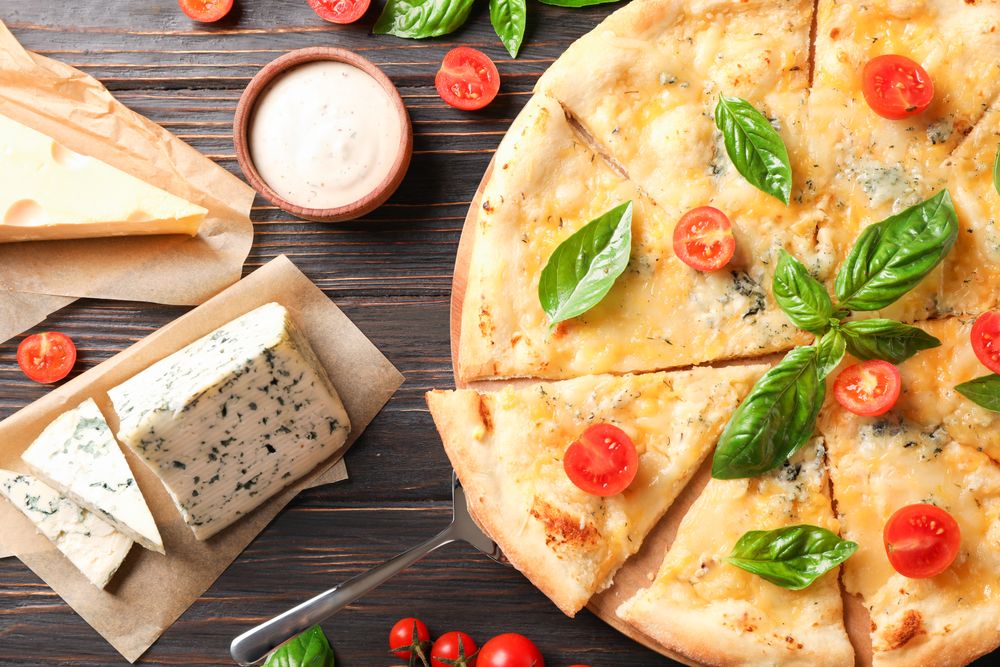 Cheese pizza and ingredients on wooden background, top view