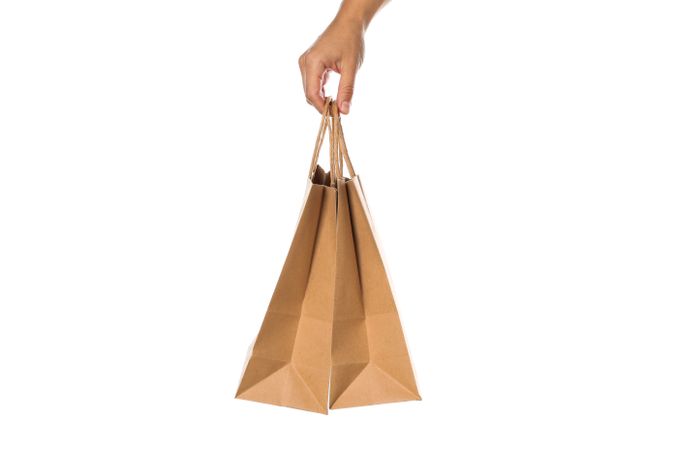 Female hand hold paper bags isolated on blank background