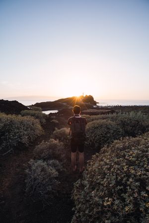 Photographer walking on seaside at sunset