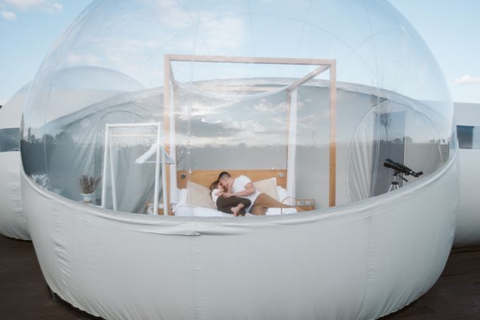 Passionate couple on bed in bubble hotel