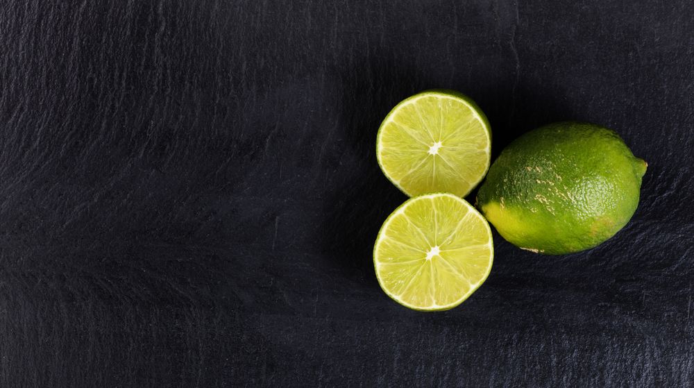 Overhead view of organic limes on slate background