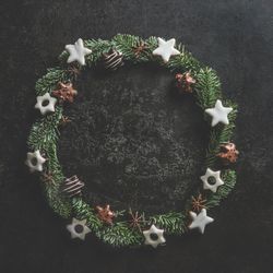 Christmas circle frame made with fir wreath and cookies on dark concrete kitchen table