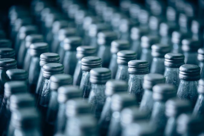 Multiple bottles of fruit juice are arranged in rows, creating a colorful and organized background.