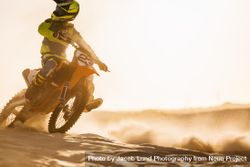 Motocross racer riding motorcycle in desert 0JOMp5