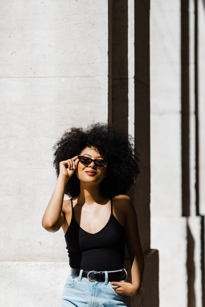 Cheerful Black female in dark sunglasses