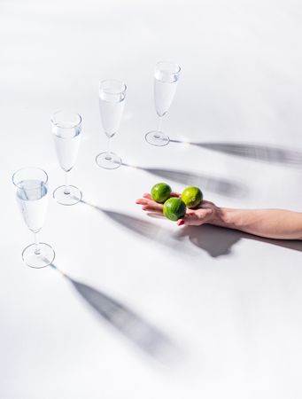 Composition of a hand with citrus and glasses of water