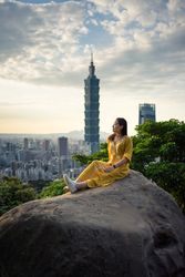 Young resting woman delighting in views in rock at big city
