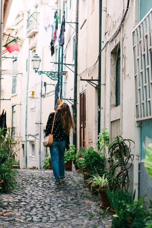 Young casual brunette standing on cobblestone street of old city