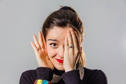 Woman with red lips using her hand to cover one eye