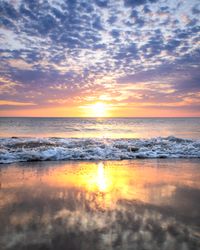 Cloudy sky above sea oceans waves on shore during sunset